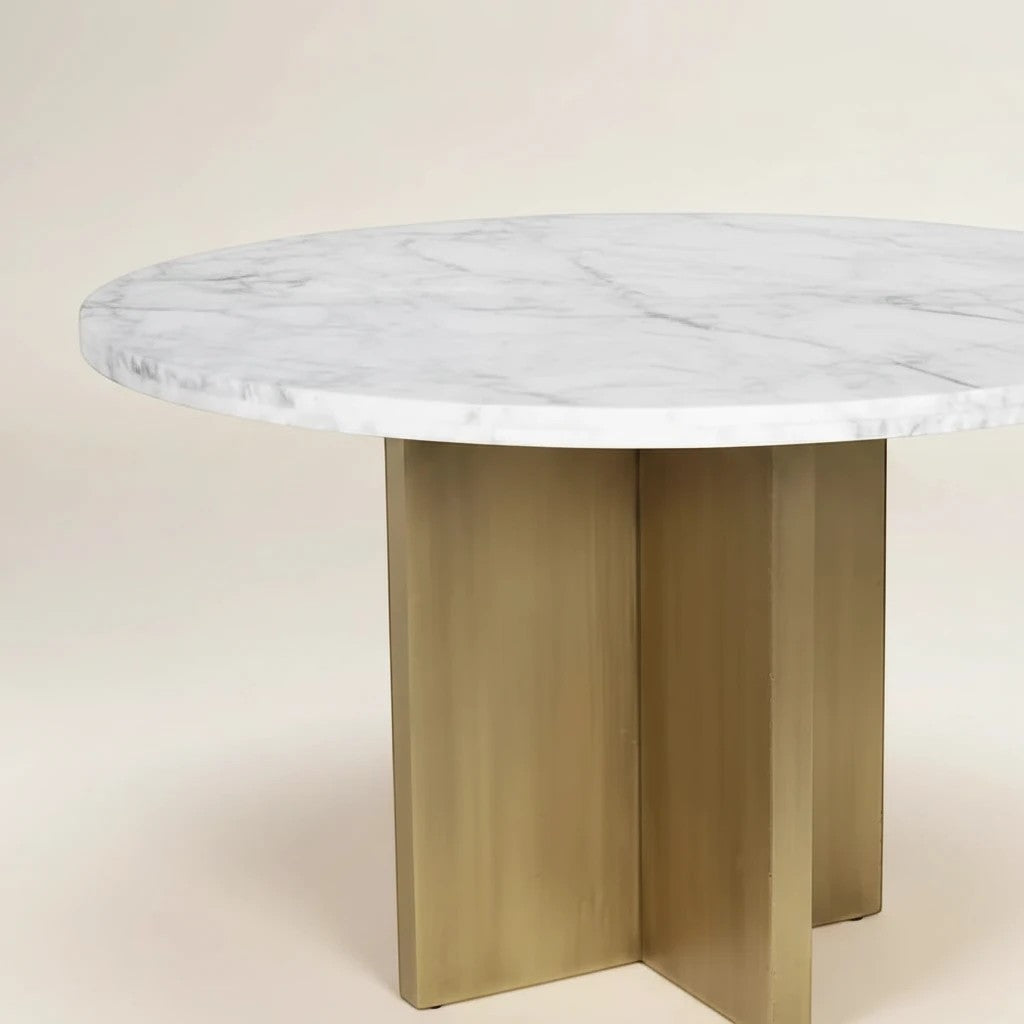 Trộm vía round white marble dining table with unique veining and a brushed gold pedestal base.